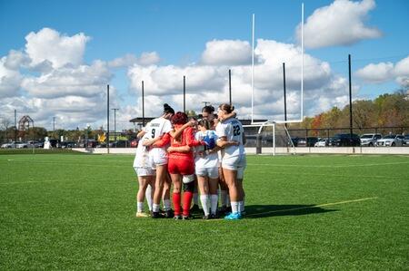 Female soccer players gathered together on a field